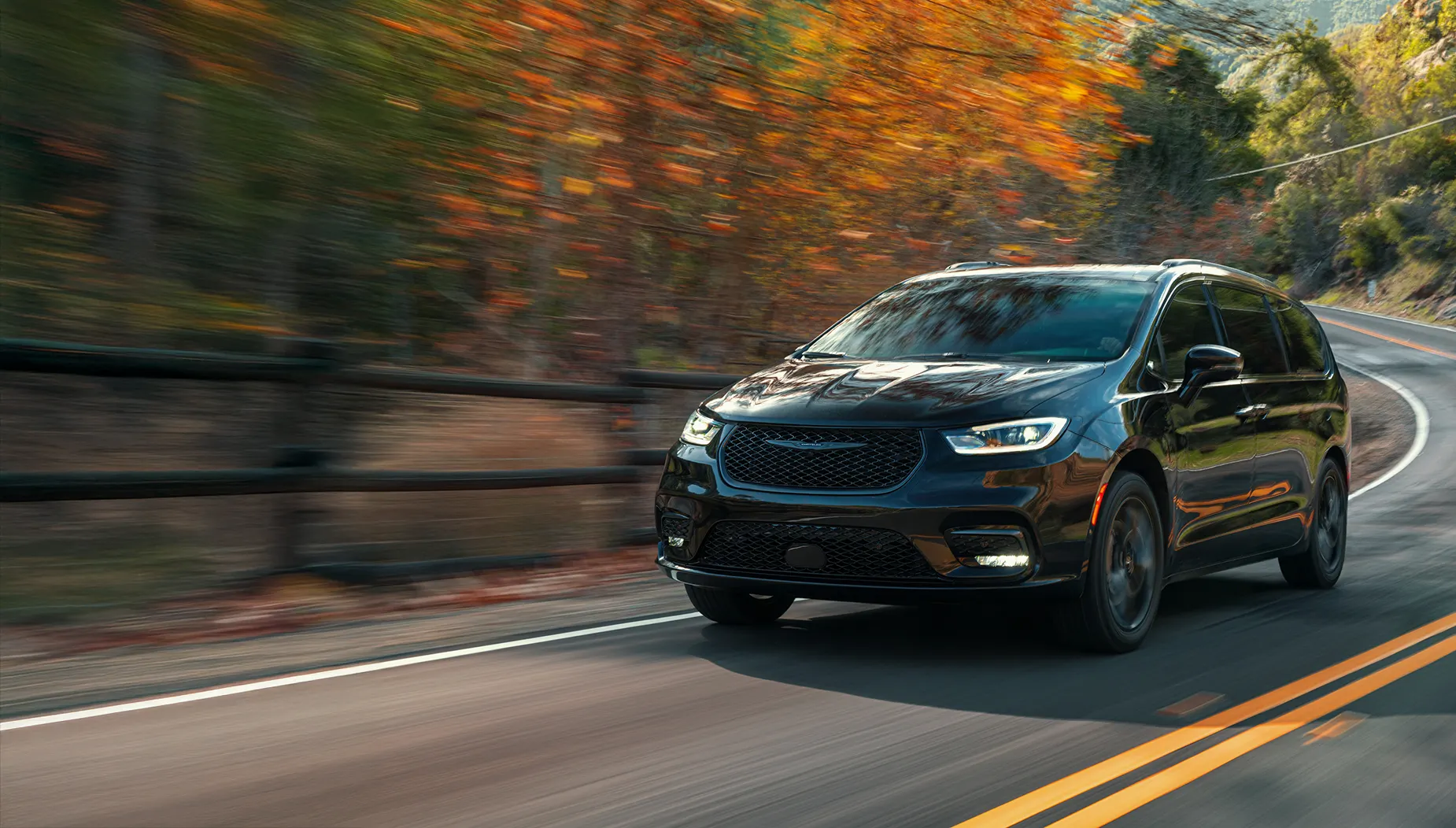 Czarny samochód na jesiennej drodze